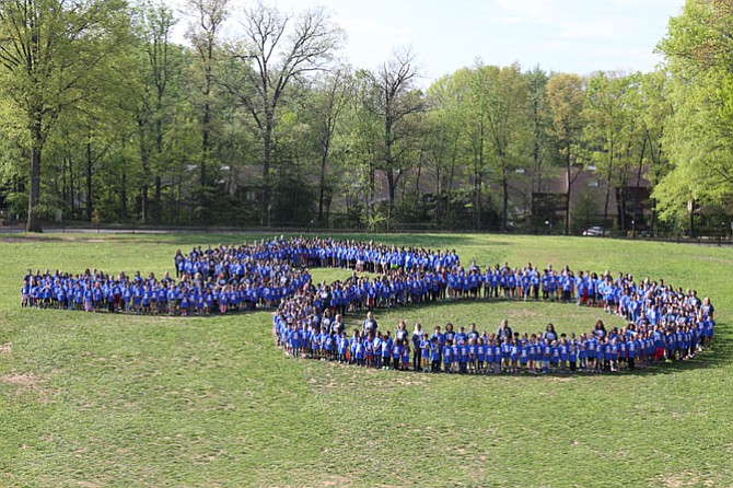 Lake Anne Elementary School students form a giant number 50 in the grass outside of the school while wearing blue t-shirts the parent-teacher association bought for them on the day of the celebration.