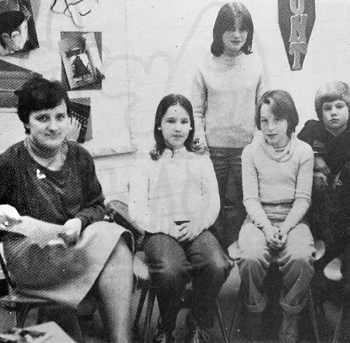 Black and white yearbook photograph of Gudula Dunn's German language class. The teacher and four students are pictured seated in a classroom. 