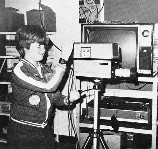 Black and white yearbook photograph of a student operating a camera for a WLAS TV production.  